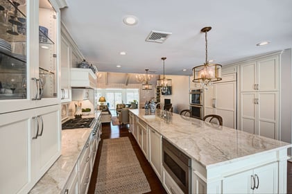 Marble kitchen counters and long island with white cabinets