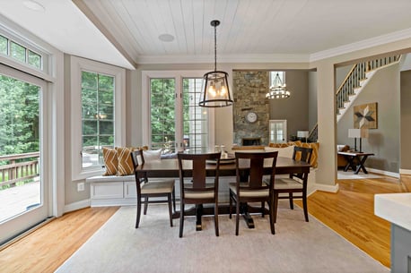 Dining room table with breakfast nook couch overlooking backyard